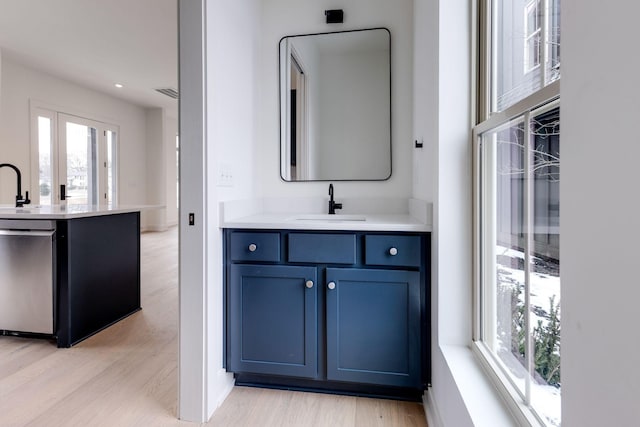 bathroom with recessed lighting, visible vents, vanity, and wood finished floors