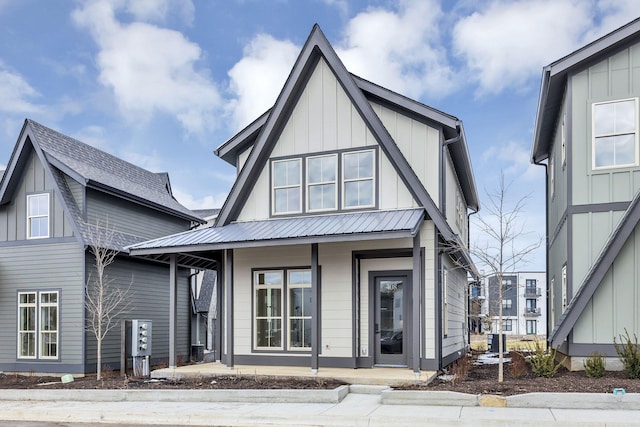 view of front of house featuring board and batten siding, central air condition unit, metal roof, and a porch