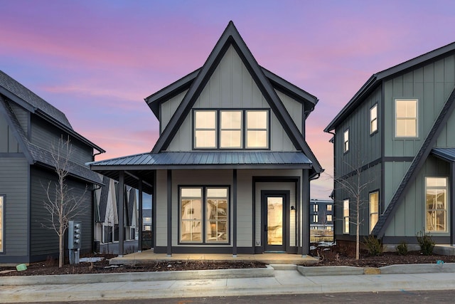 entrance to property with board and batten siding, metal roof, and a porch