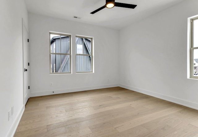 empty room featuring visible vents, ceiling fan, light wood-style flooring, and baseboards