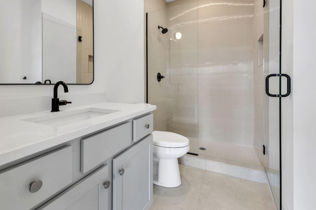 bathroom with tile patterned flooring, toilet, vanity, and a shower stall