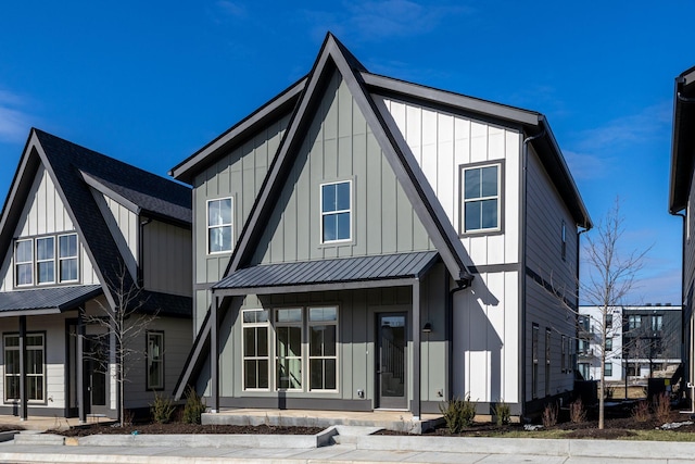 back of property with a standing seam roof, metal roof, and board and batten siding