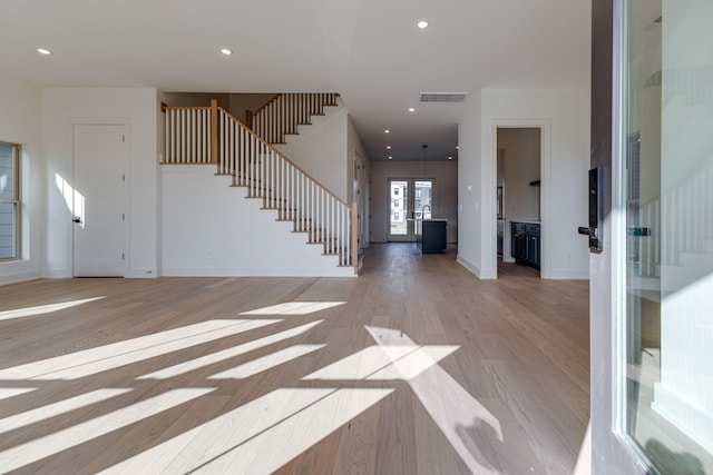 foyer entrance featuring light wood finished floors, recessed lighting, visible vents, stairway, and baseboards