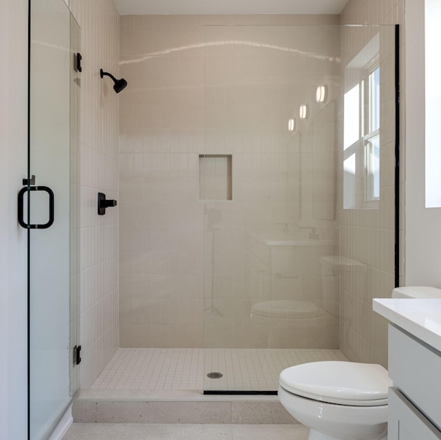 bathroom featuring a stall shower, vanity, and toilet