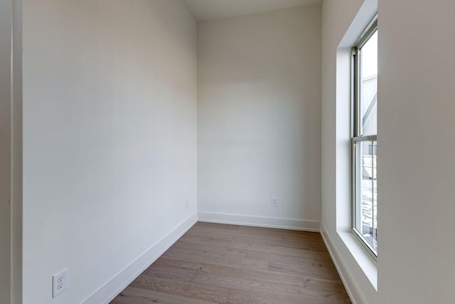 unfurnished room with light wood finished floors and baseboards