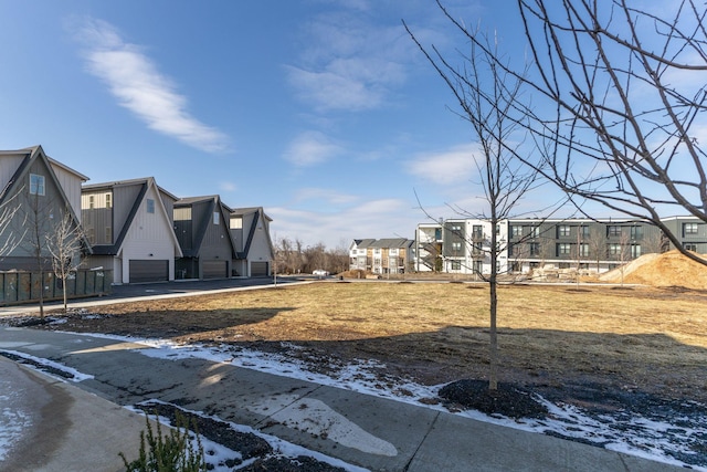 yard layered in snow with a garage and a residential view