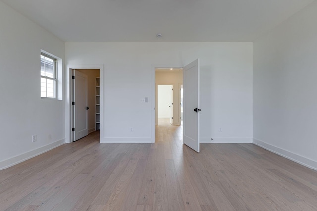 unfurnished room featuring baseboards and light wood finished floors