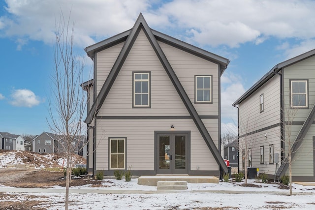 snow covered property featuring central air condition unit and french doors