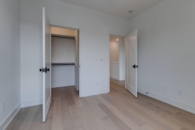 unfurnished bedroom with light wood-style floors and baseboards