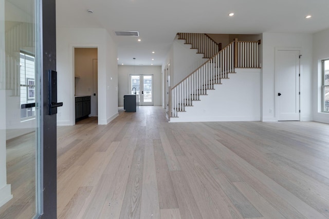 foyer entrance with recessed lighting, visible vents, light wood-type flooring, baseboards, and stairs