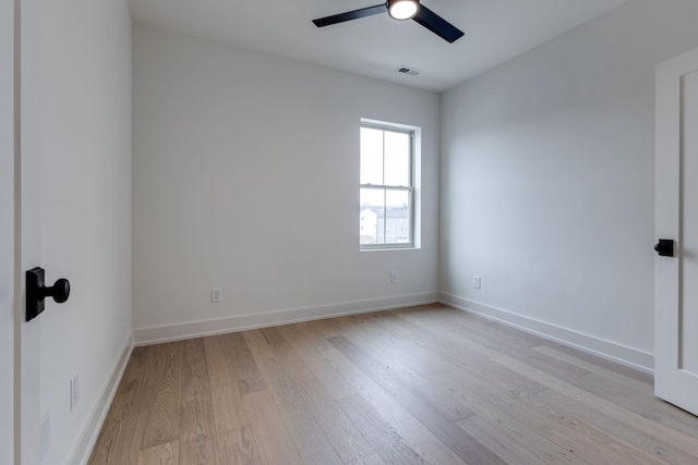 spare room featuring baseboards, ceiling fan, visible vents, and light wood-style floors