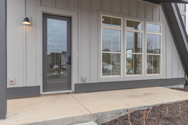 doorway to property with board and batten siding and a patio area