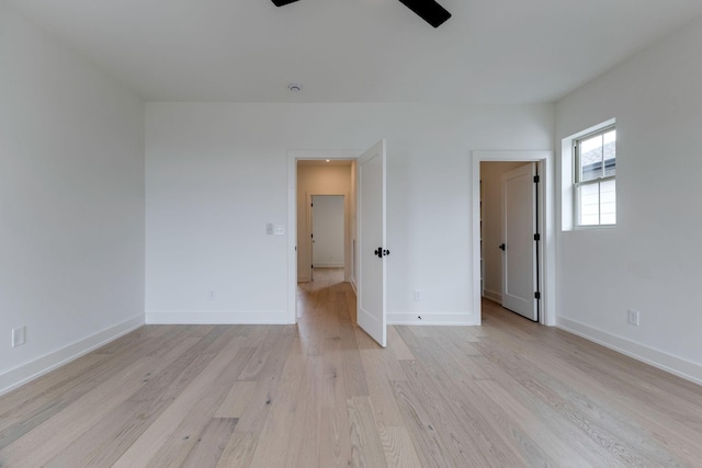 unfurnished bedroom with light wood-style flooring, baseboards, and a ceiling fan