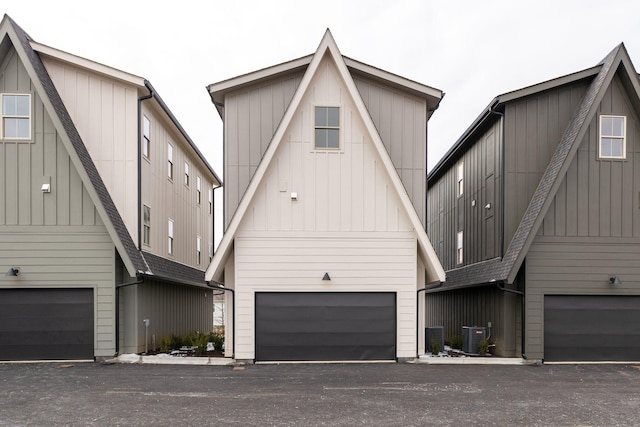 view of front of home featuring a garage, central AC unit, and board and batten siding