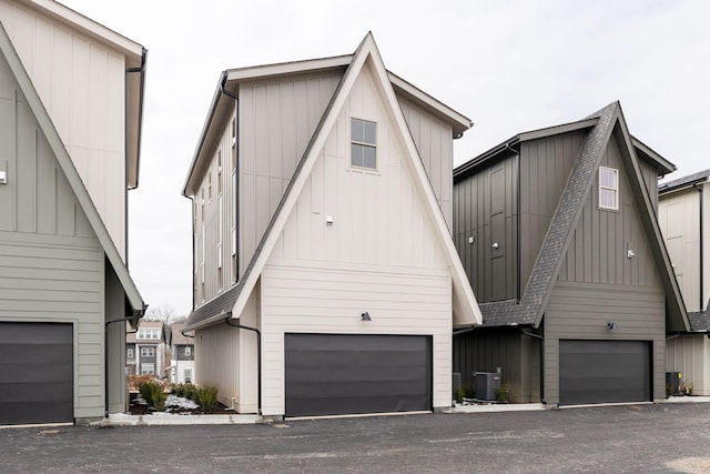 view of front of home featuring a garage, central AC unit, and board and batten siding