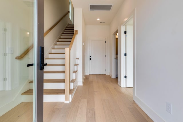 interior space featuring stairs, light wood finished floors, visible vents, and baseboards