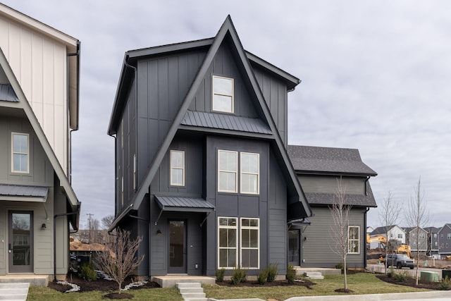 view of front of house with metal roof, a front lawn, and board and batten siding