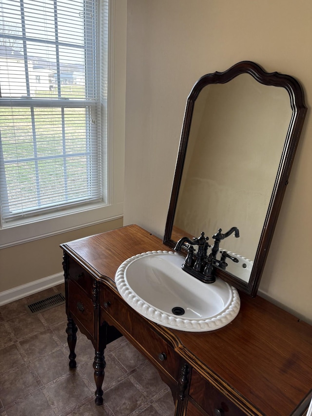 bathroom with tile patterned floors, a sink, visible vents, and baseboards