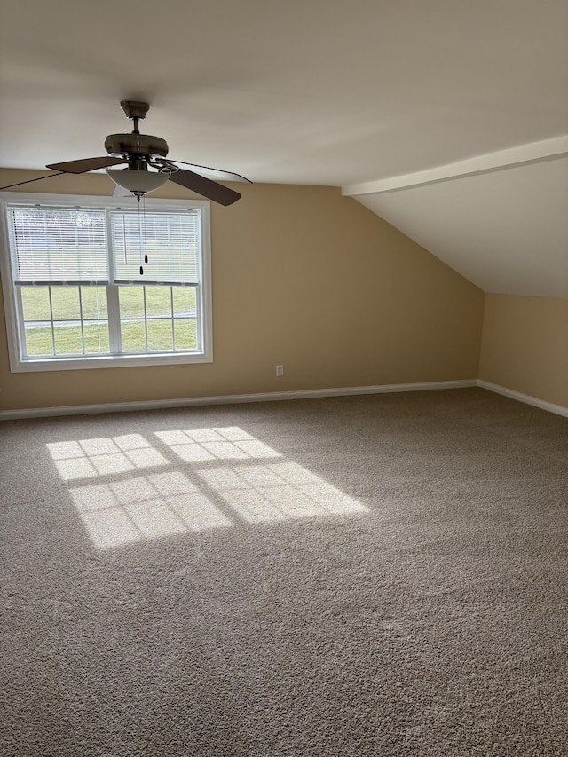 additional living space with vaulted ceiling with beams, light carpet, a ceiling fan, and baseboards