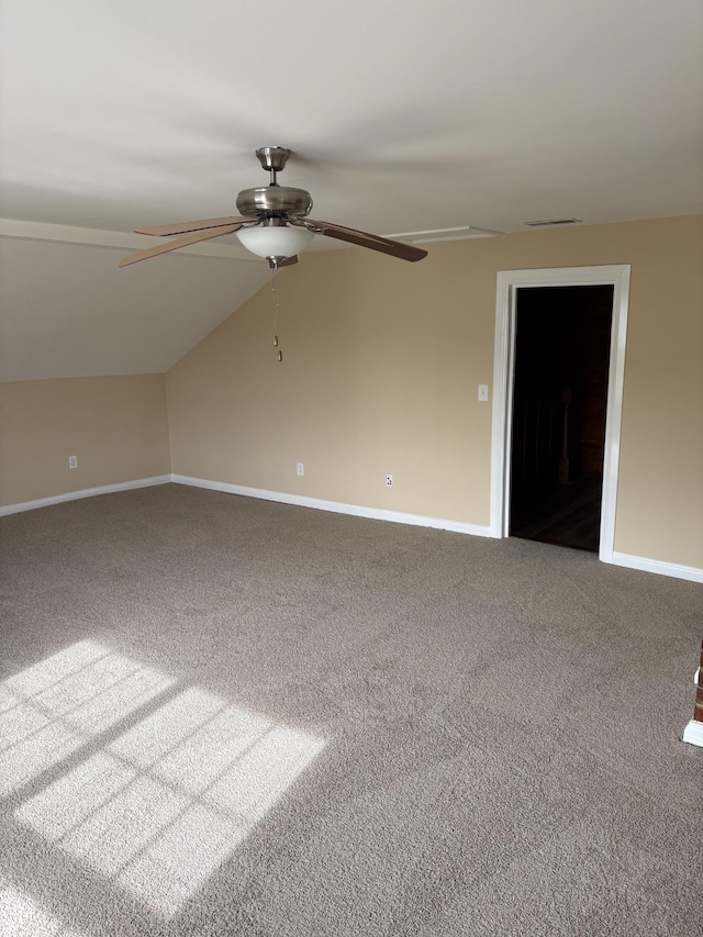 additional living space featuring carpet floors, lofted ceiling, baseboards, and a ceiling fan