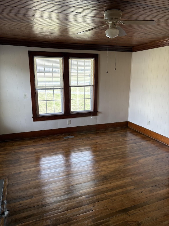 spare room with dark wood finished floors, visible vents, ceiling fan, wooden ceiling, and baseboards