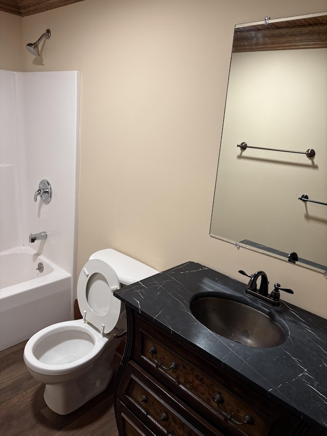 bathroom featuring toilet, vanity, wood finished floors, and shower / bathtub combination