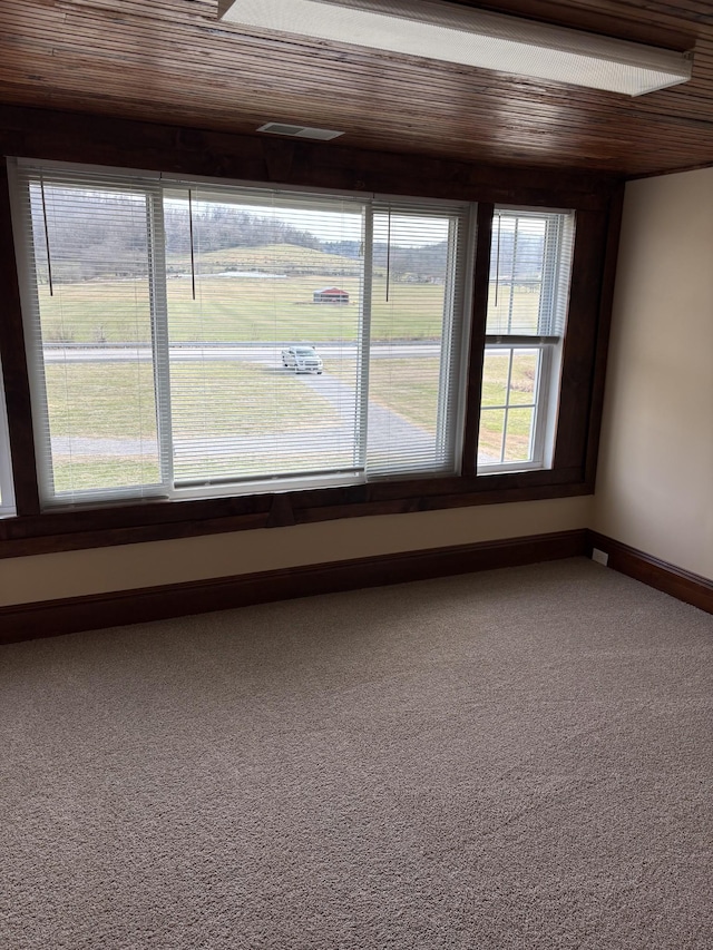 unfurnished room with carpet floors, wooden ceiling, and baseboards