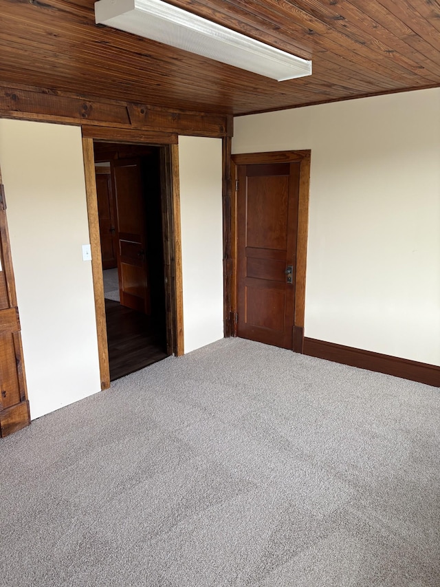 unfurnished bedroom featuring carpet floors and wood ceiling