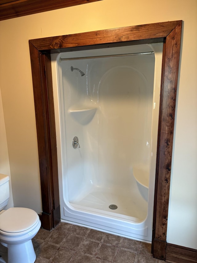 bathroom featuring a shower stall and toilet