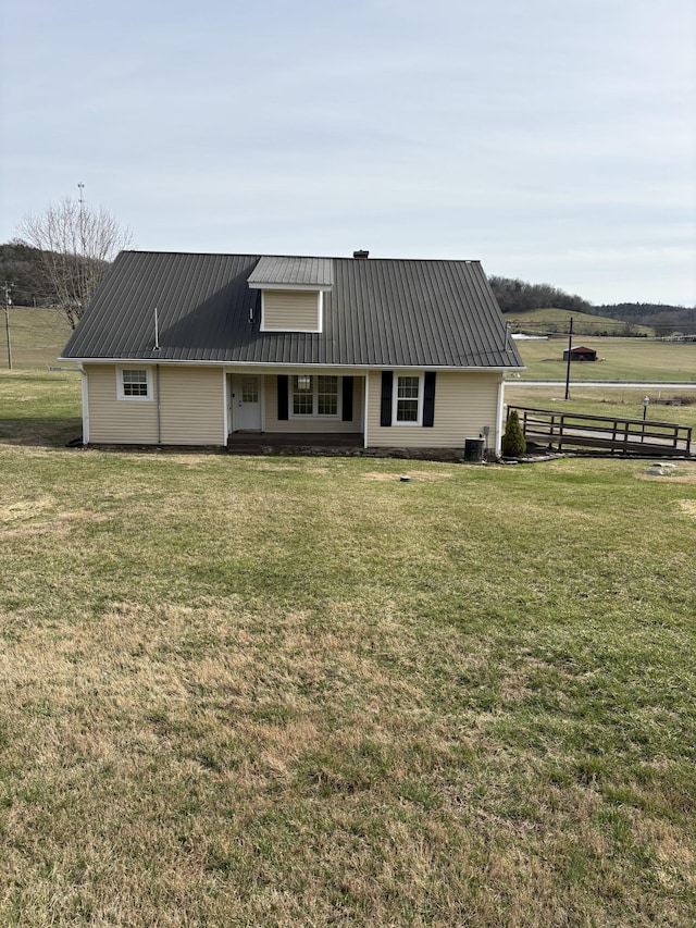 view of front of home featuring metal roof, a front lawn, and a rural view