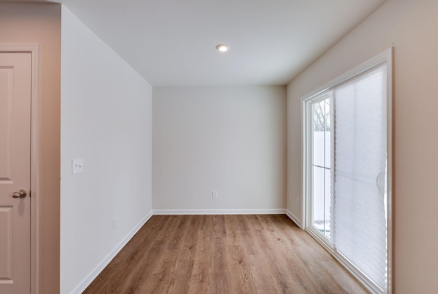 empty room featuring light wood finished floors and baseboards