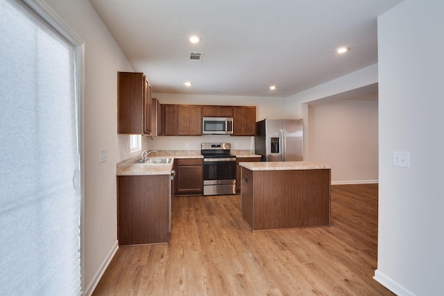 kitchen featuring a kitchen island, visible vents, light countertops, appliances with stainless steel finishes, and light wood finished floors