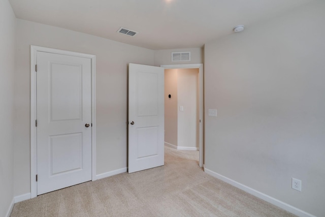 unfurnished bedroom with baseboards, visible vents, and light colored carpet