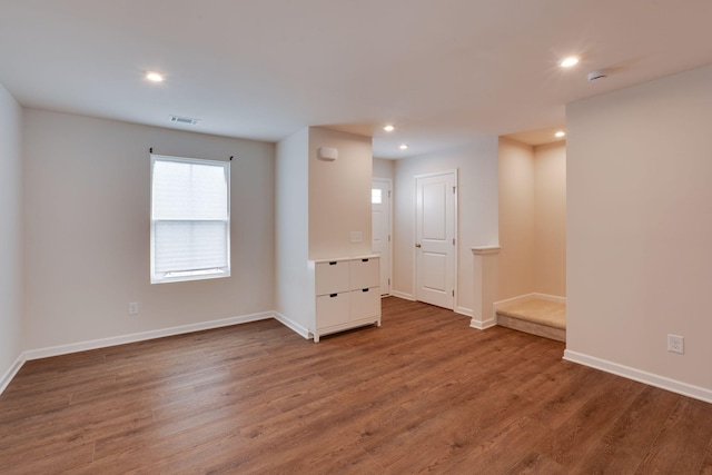 unfurnished room with dark wood-style floors, baseboards, visible vents, and recessed lighting