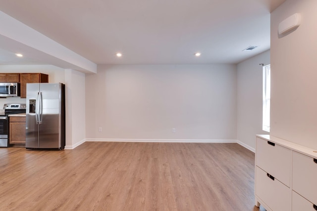 kitchen featuring light wood finished floors, baseboards, brown cabinetry, appliances with stainless steel finishes, and recessed lighting