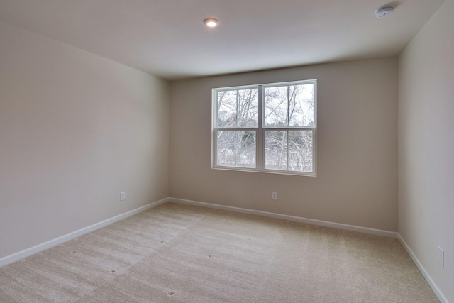 empty room with baseboards and light colored carpet