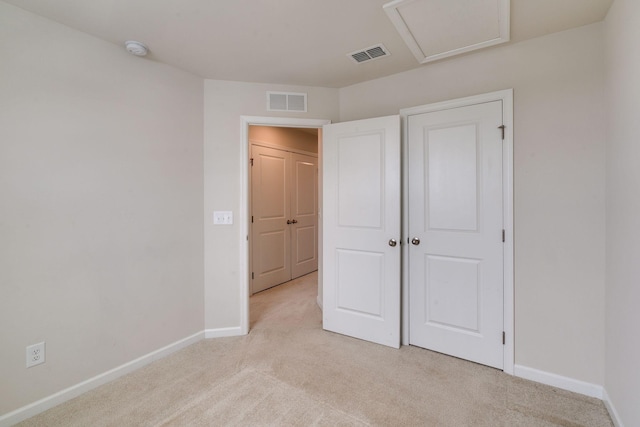 unfurnished bedroom featuring light colored carpet, visible vents, and baseboards