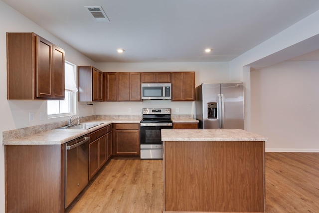 kitchen featuring light wood-style flooring, a sink, visible vents, light countertops, and appliances with stainless steel finishes