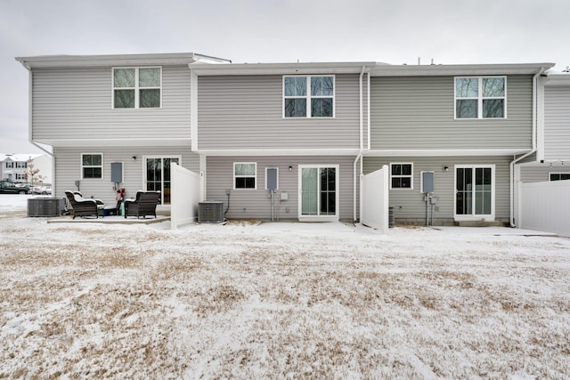 snow covered property featuring fence and central AC unit