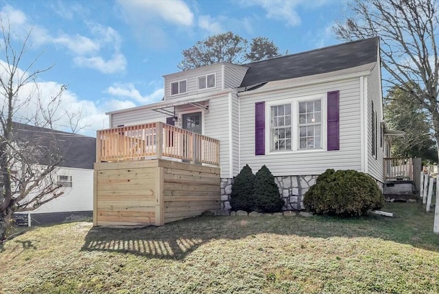 view of front facade with a wooden deck and a front yard