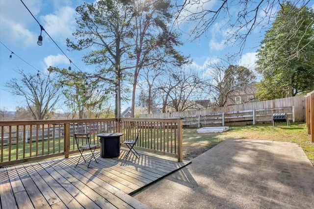 wooden deck featuring a yard, a patio, and a fenced backyard