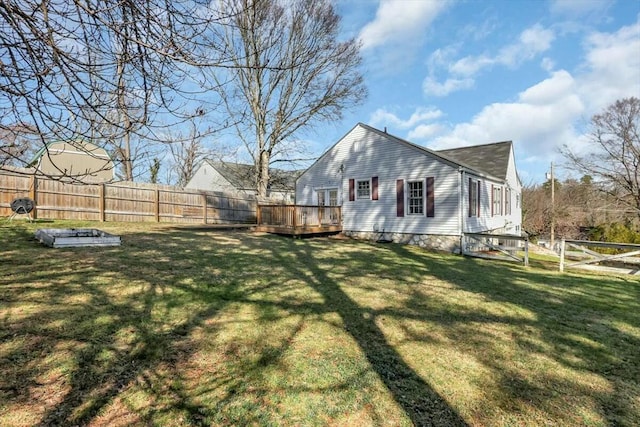 view of side of property with a deck, a lawn, and a fenced backyard