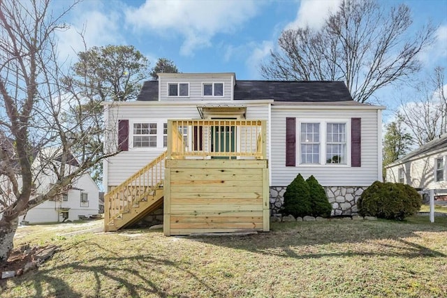 rear view of property with stairs and a yard