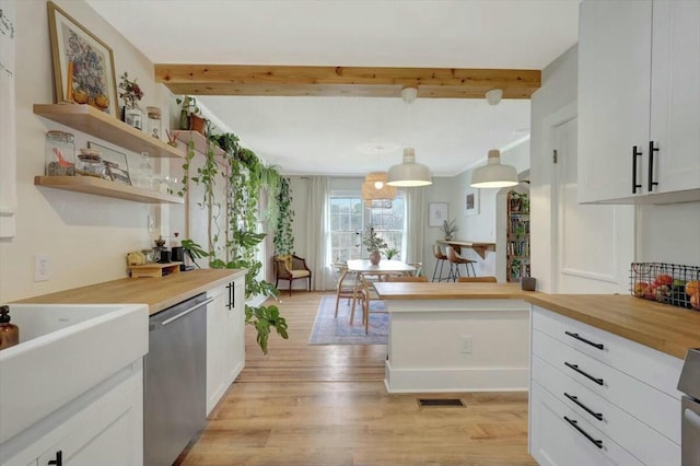 kitchen with decorative light fixtures, open shelves, white cabinets, wood counters, and dishwasher