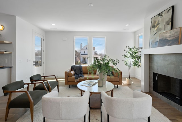 living room featuring wood finished floors, recessed lighting, a fireplace, and baseboards