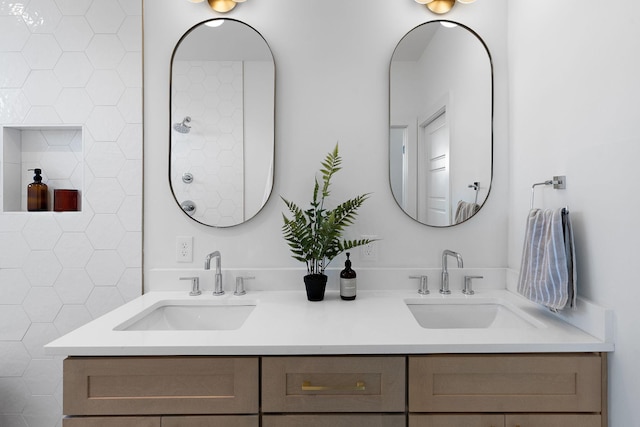 full bath with double vanity, a tile shower, and a sink