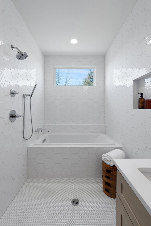 bathroom with tiled bath, tile walls, tiled shower, tile patterned floors, and vanity