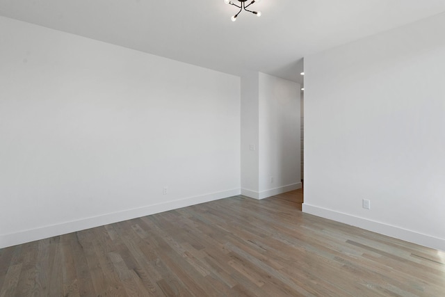 unfurnished room featuring baseboards and wood finished floors