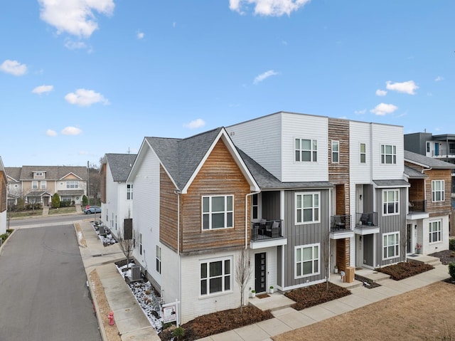 multi unit property with central air condition unit, a residential view, and board and batten siding