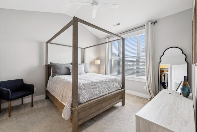 bedroom with lofted ceiling, light colored carpet, visible vents, and baseboards